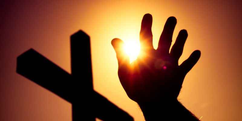 Man's Hand with Sun and a Catholic Cross Silhouette