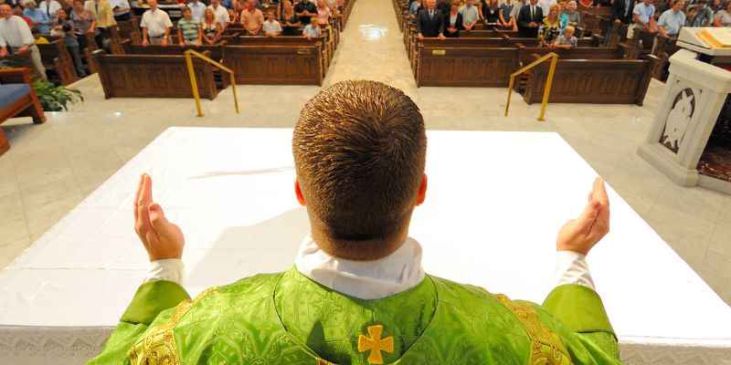 Roman Catholic Priest During A Mass Leading A Prayer